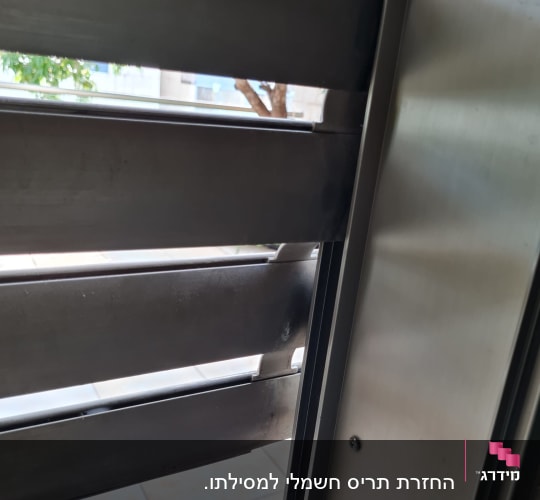 תריסים מתכתיים פתוחים עם אור עובר ביניהם